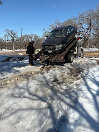 Tow truck picking up a junk car in Dallas, TX